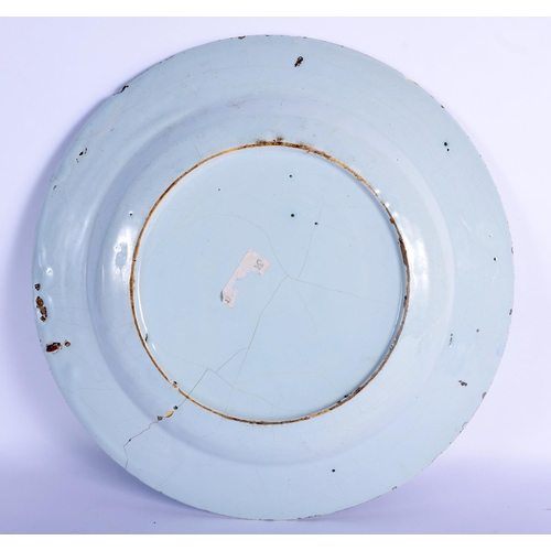 26 - A LARGE 18TH CENTURY DELFT BLUE AND WHITE TIN GLAZED CIRCULAR PLATE painted with flowers and gardens... 