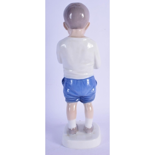 314 - A ROYAL COPENHAGEN PORCELAIN FIGURE OF A BOY modelled eating fruit. 18 cm high.