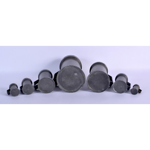 371 - SEVEN ANTIQUE PEWTER MEASURES. Largest 24 cm high. (7)