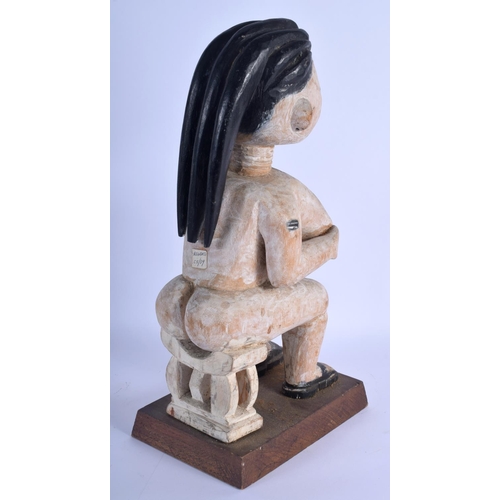 372 - AN AFRICAN WHITE PAINTED TRIBAL CARVED WOOD FIGURE modelled upon a stool. 40 cm high.