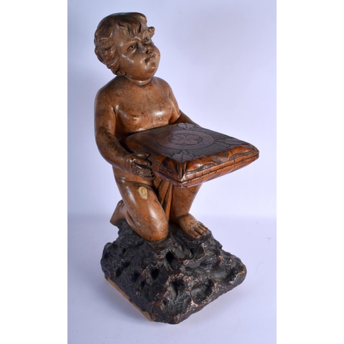 384 - AN 18TH/19TH CENTURY EUROPEAN CARVED WOOD FIGURE OF A KNEELING BOY modelled holding a pillow decorat... 