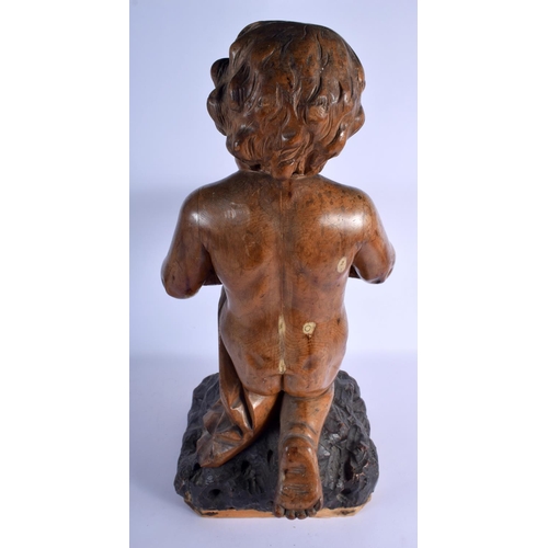 384 - AN 18TH/19TH CENTURY EUROPEAN CARVED WOOD FIGURE OF A KNEELING BOY modelled holding a pillow decorat... 