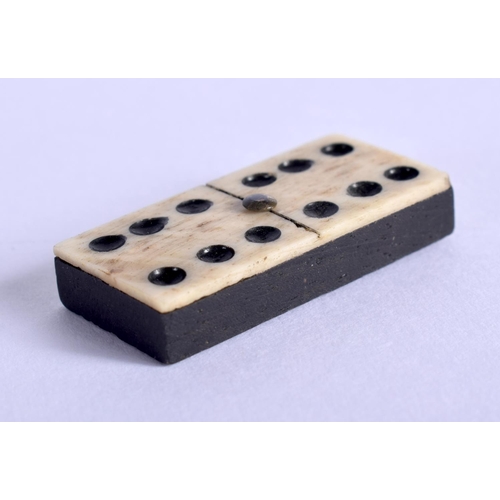 391 - AN ANTIQUE CARVED DOMINO SET together with a bowman tinplate train. Largest 24 cm long. (2)