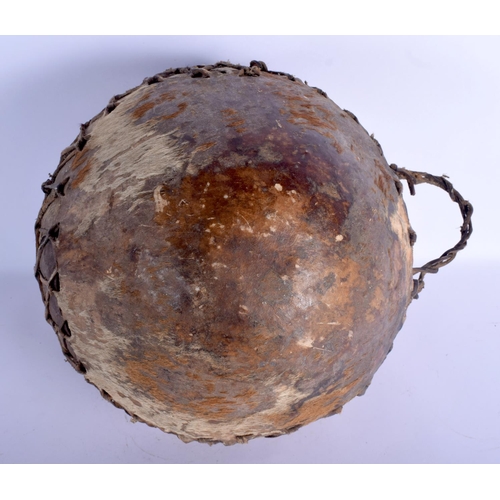 400 - AN EARLY 20TH CENTURY AFRICAN HIDE COVERED ANIMAL SKIN DRUM of naturalstic form. 27 cm x 21 cm.