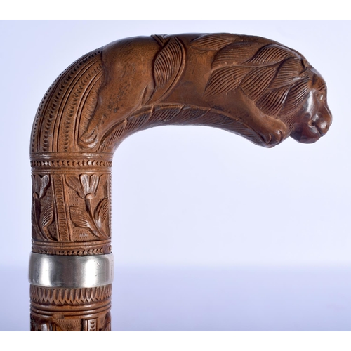 409 - A 19TH CENTURY ANGLO INDIAN CARVED WOOD WALKING CANE with lion head handle, decorated with foliage a... 