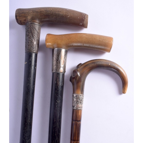 410 - TWO 19TH CENTURY CONTINENTAL CARVED RHINOCEROS HORN HANDLED WALKING CANES together with another horn... 