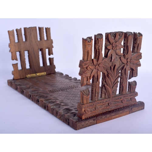 437 - A 19TH CENTURY BAVARIAN BLACK FOREST SLIDING WOOD BOOK RACK formed with foliage and gate posts. 46 c... 
