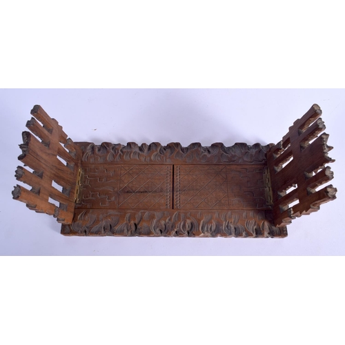 437 - A 19TH CENTURY BAVARIAN BLACK FOREST SLIDING WOOD BOOK RACK formed with foliage and gate posts. 46 c... 