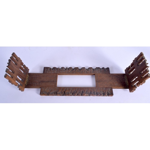 437 - A 19TH CENTURY BAVARIAN BLACK FOREST SLIDING WOOD BOOK RACK formed with foliage and gate posts. 46 c... 