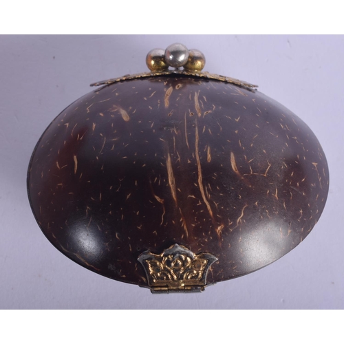 445 - AN ANTIQUE TRIBAL CARVED COCONUT SHELL PURSE with yellow and white metal mounts. 10 cm x 7 cm.