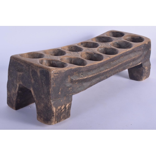 454 - AN UNUSUAL VINTAGE TRIBAL CARVED WOOD MANCALA GAMING BOARD with carved nut counters. Board 50 cm x 1... 