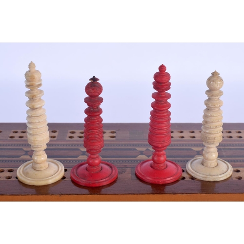 477 - AN ANTIQUE CARVED AND STAINED BONE CHESS SET within a cribbage case. Largest 6.5 cm high. (qty)