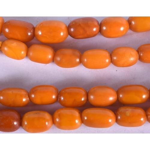 1036 - AN AMBER NECKLACE.  76cm long, Largest bead 18 mm diameter, weight 48g