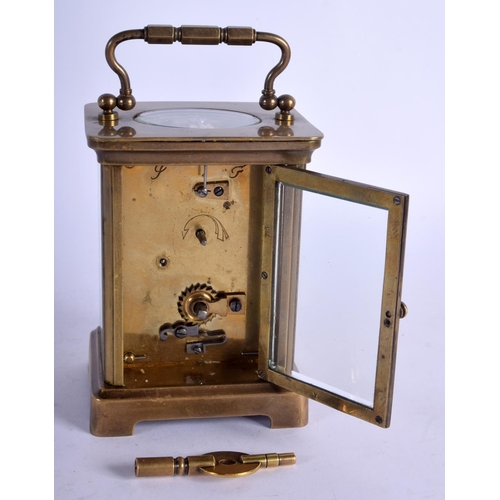 1082 - A BRASS CARRIAGE CLOCK.  10.8cm high (13.8cm with handle raised) x 7.9cm x 6.3cm with key