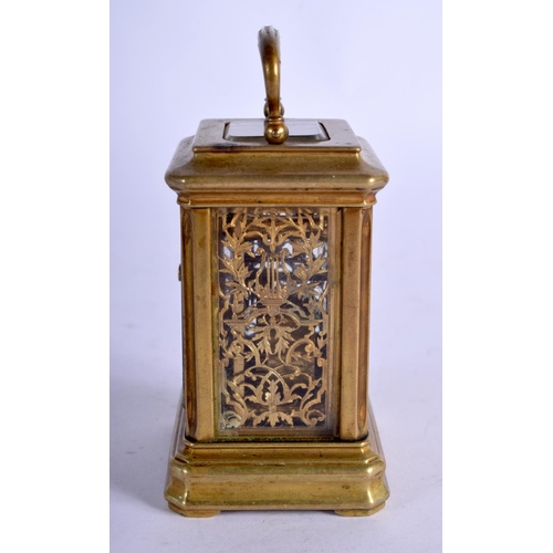 1084 - A MINIATURE BRASS CARRIAGE CLOCK.  7.4cm high (9.2cm with handle raised) x 5.1cm x 4cm