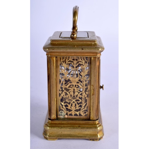 1084 - A MINIATURE BRASS CARRIAGE CLOCK.  7.4cm high (9.2cm with handle raised) x 5.1cm x 4cm