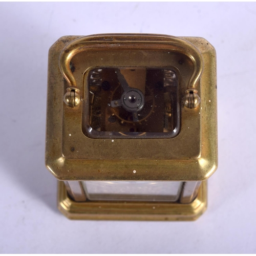 1084 - A MINIATURE BRASS CARRIAGE CLOCK.  7.4cm high (9.2cm with handle raised) x 5.1cm x 4cm