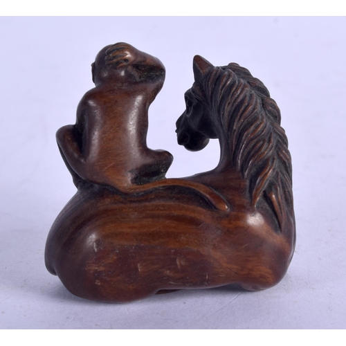 1131 - A JAPANESE WOOD NETSUKE IN FOR FORM OF A HORSE WITH A MONKEY ON ITS BACK.  4.4cm x 4.4cm, weight 24.... 