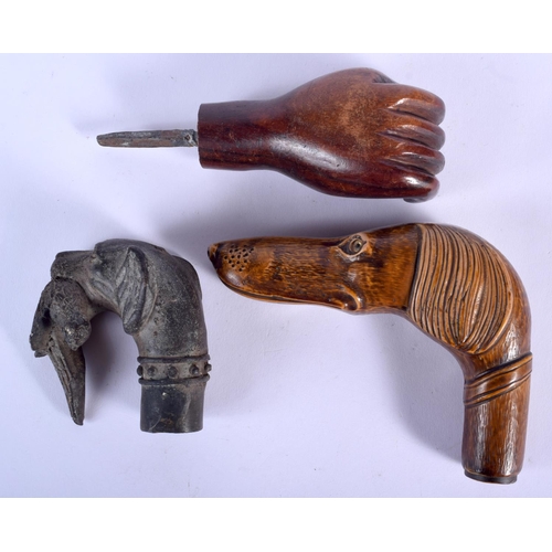 180 - AN ANTIQUE CARVED TREEN DOG HEAD WALKING CANE HANDLE together with two others. Largest 13 cm x 8 cm.... 