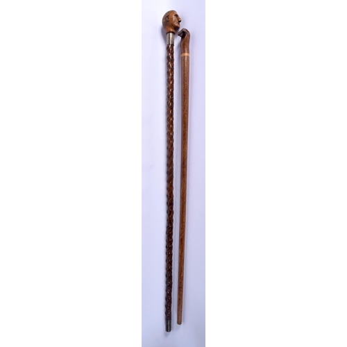 866 - AN 18TH/19TH CENTURY CARVED FRUITWOOD WALKING CANE together with a similar later fist cane. Largest ... 