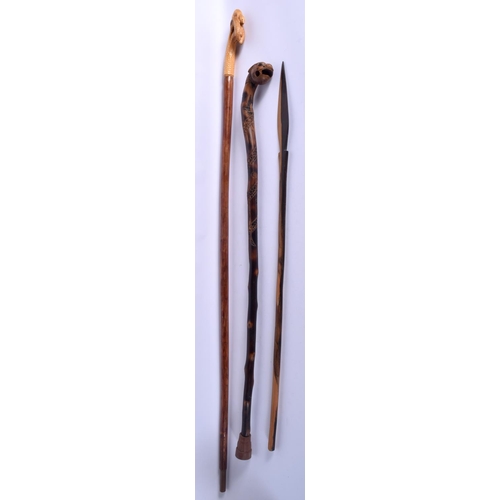 867 - A SOUTH EAST ASIAN BAMBOO TYPE WALKING CANE together with two others. Largest 90 cm. (3)