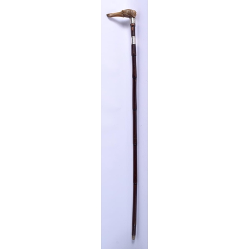 872 - AN ANTIQUE CARVED RHINOCEROS HORN SILVER MOUNTED WALKING CANE with bamboo type shaft. 86 cm long.