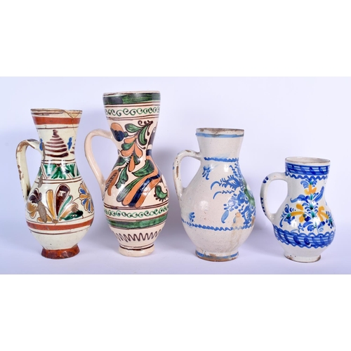 90 - FOUR EASTERN EUROPEAN TIN GLAZED POTTERY JUGS in various forms and sizes. Largest 25 cm high. (4)