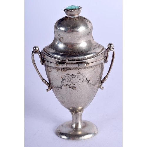 915 - AN ANTIQUE MINIATURE WHITE METAL URN AND COVER INSET WITH A GEM TOP.  8cm high, 5cm wide