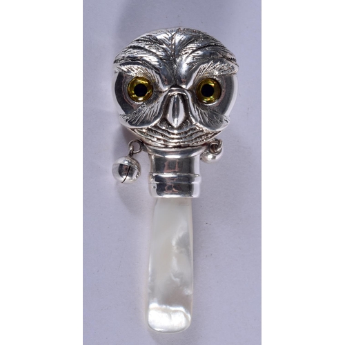 930 - A BABIES TEETHING RATTLE IN FOR FORM OF AN OWL WITH GEM SET EYES.  7.5cm x 3cm, weight 13.5g