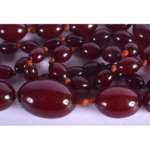 990 - A CHERRY AMBER NECKLACE.  104cm long, largest bead 20.4mm, weight 74g