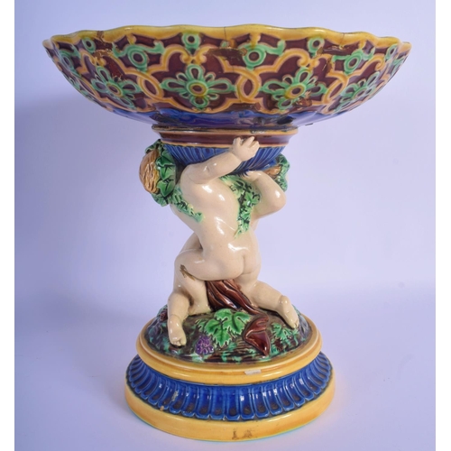 51 - A 19TH MINTON MAJOLICA PEDESTAL DOUPLE PUTTI CENTREPIECE modelled upon a base overlaid with flowers.... 