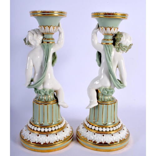 113 - MINTON PAIR OF SEVRES STYLE CHERUB CELADON CANDLESTICKS WITH GILT HIGHLIGHTS C.1880.24cm high (Pr)