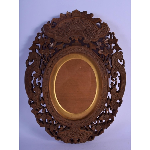 324 - A 19TH CENTURY INDIAN MIDDLE EASTERN CARVED SANDALWOOD FRAME decorated with flowers and vines. 30 cm... 