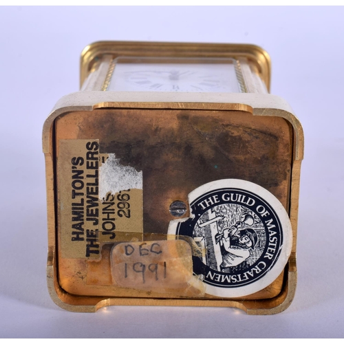 380 - A CASED MINIATURE ANTIQUE BRASS CARRIAGE CLOCK. 8.75 cm high inc handle.