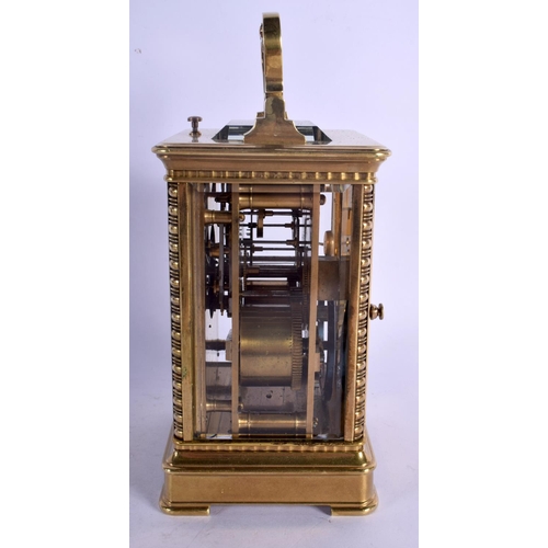 391 - A FINE REPEATING BRASS CARRIAGE CLOCK with well decorated floral face. 18.5 cm high inc handle.