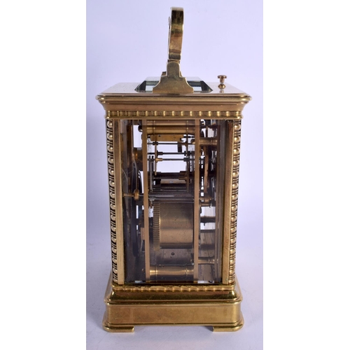 391 - A FINE REPEATING BRASS CARRIAGE CLOCK with well decorated floral face. 18.5 cm high inc handle.