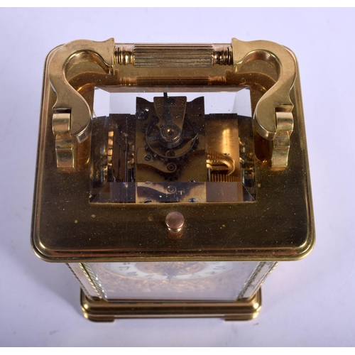 391 - A FINE REPEATING BRASS CARRIAGE CLOCK with well decorated floral face. 18.5 cm high inc handle.