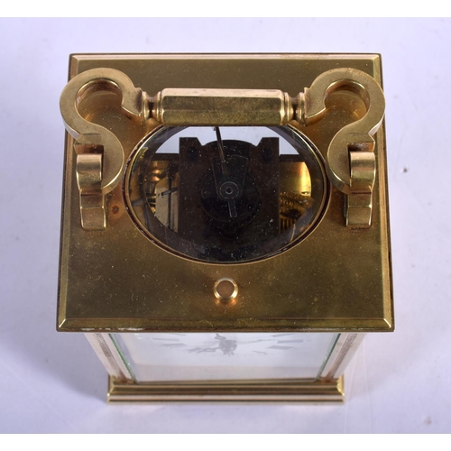 392 - A FRENCH REPEATING BRASS CARRIAGE CLOCK with enamelled dial. 15 cm high inc handle.