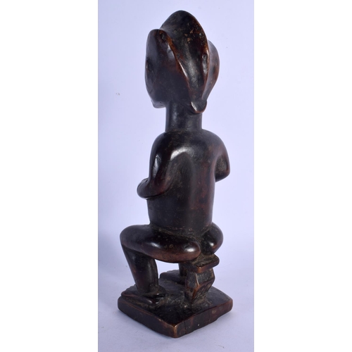 399 - AN UNUSUAL AFRICAN TRIBAL CARVED WOOD FIGURE modelled with inset stud work and scarred face. 25 cm h... 