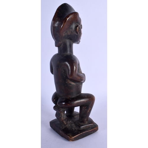 399 - AN UNUSUAL AFRICAN TRIBAL CARVED WOOD FIGURE modelled with inset stud work and scarred face. 25 cm h... 