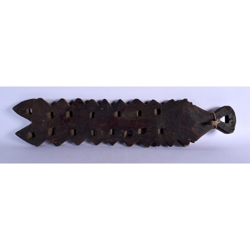401 - AN UNUSUAL TRIBAL CARVED WOOD HANGING BOARD possibly a mancala board. 70 cm x 14 cm.