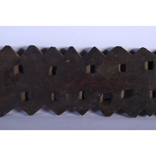 401 - AN UNUSUAL TRIBAL CARVED WOOD HANGING BOARD possibly a mancala board. 70 cm x 14 cm.