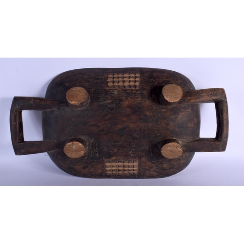 402 - AN AFRICAN TRIBAL CARVED TWIN HANDLED FOOD SERVING BOWL with chip carved backing. 62 cm x 28 cm.