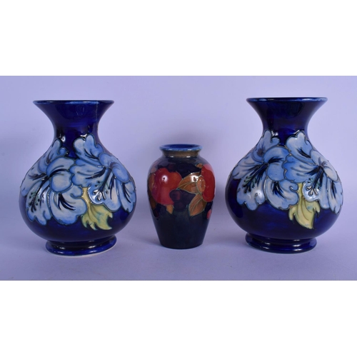 47 - A PAIR OF MOORCROFT VASES and a William Moorcroft pomegranate vase. Largest 15 cm high. (3)