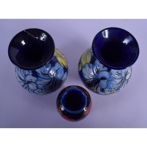47 - A PAIR OF MOORCROFT VASES and a William Moorcroft pomegranate vase. Largest 15 cm high. (3)