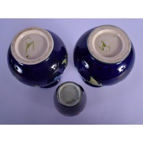 47 - A PAIR OF MOORCROFT VASES and a William Moorcroft pomegranate vase. Largest 15 cm high. (3)