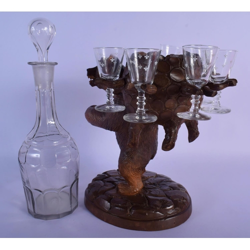 55 - A 19TH CENTURY BAVARIAN BLACK FOREST CARVED WOOD LIQUOR SET with glasses and decanter. Bear 27 cm x ... 