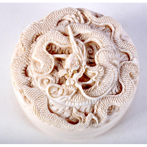 16 - A 19TH CENTURY JAPANESE MEIJI PERIOD CARVED IVORY BOX AND COVER decorated with dragons. 7 cm diamete... 