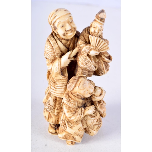 29 - A 19TH CENTURY JAPANESE MEIJI PERIOD CARVED IVORY OKIMONO modelled as a male with two other figures.... 
