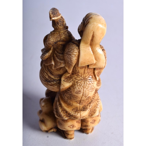 29 - A 19TH CENTURY JAPANESE MEIJI PERIOD CARVED IVORY OKIMONO modelled as a male with two other figures.... 